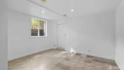 2nd of two full-height bedrooms downstairs. Also has the proper window well for egress. Door in this picture leads to backyard.