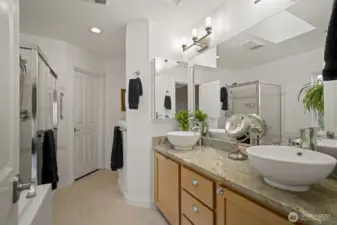Updated 5 piece bathroom with soaking tub, tiled shower, 12 x 24 tiled floors and dual vanities with vessel sinks.