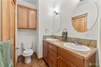 Upper full bath has double sinks, tiled floor and counters.