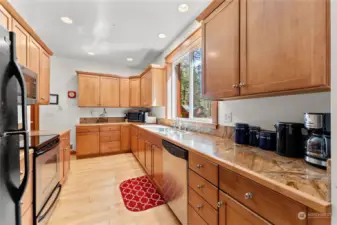 Hardwood honey maple floors, ceramic tiled counter blends perfectly with Cabinets and trim. Double stainless sink, Electric range/ oven, dishwasher, fridge are included Kitchen appliances.