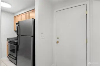 The wall-side of the kitchen has a stainless steel fridge, stainless steel stove/oven, a stainless steel microwave, plus counters and cabinets. Everything is clean and in good condition. Move-in ready!