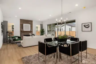 Open concept dining area and great room with multi stack slider panel doors open to covered patio