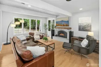 Cozy living room with wood burning fireplace looking out to the private yard.