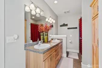 Hickory cabinets in the jack and Jill bathroom connects two guest rooms.
