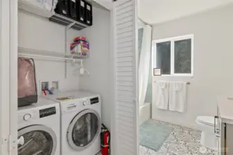 Laundry room with shelving for storage.