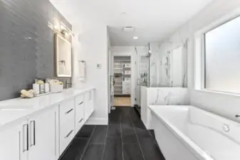 Primary bathroom with heated floors, floating vanity, backlit mirrors, soaking tub, and massive shower