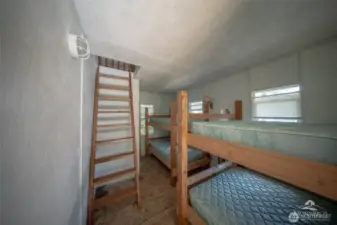 Interior of guest cabin with extra sleeping quarters on both levels. Power and small sink.