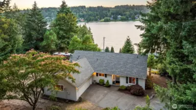 Charming North Gig Harbor one-level home framed by evergreens with views of Burley Lagoon—enjoy water views, wooded privacy, and peaceful surroundings all in one setting.