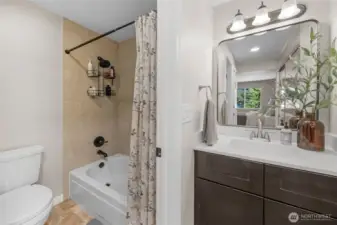 Primary bathroom with new vanity and updated fixtures in the shower and bathtub