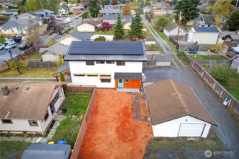 Arial image of the house from the South looking at the side yard, detached garage & solar system.