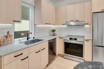 Contemporary Seattle kitchen with tile backsplash, under cabinet lighting and streamlined storage.
