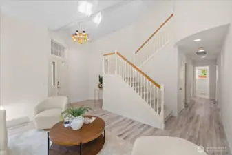 Another view of the grand staircase and down the hall to the main floor bedroom and bathroom