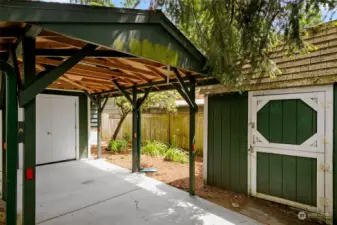 This is the carport located behind the house, accessible from the alley.  Note the storage closet at the end of the carport, along with the additional storage shed to the right.