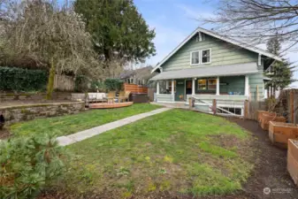 Enchanting backyard is fully fenced, with raised garden beds, a patio, AND the hot tub CAN convey!