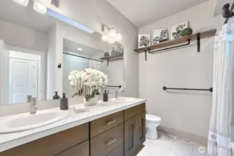 The upstairs hallway bath is both stylish and functional, serving Bedrooms #1 and #2 with ease. Featuring double sinks, it provides ample space for morning routines, while the generous cabinet storage ensures everything stays neatly organized