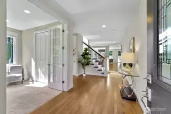 Stepping inside, you're welcomed by beautiful white oak hardwood floors that flow seamlessly throughout the main level, adding warmth and character to the space. The office, distinguished by its elegant French doors and ample closet space, offers versatility—it could easily serve as a main-floor bedroom with the adjacent well-appointed 3/4 bath featuring a shower