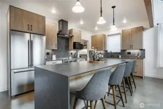 Gorgeous wood kitchen cabinets and quartz waterfall countertops. Kitchen countertops offer under-cabinet lighting.