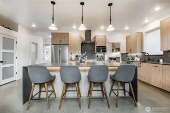Kitchen island offers under countertop lighting and Hubbardton forge pendant lights.