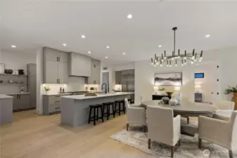 Chef's kitchen with Bellmont cabinets, large quartz island with seating and dining area