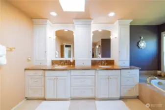 The primary bath suite has a custom-built dual sink vanity, with collonaded storage cabinets in addition to the under-sink storage cabinets.  There is recessed can lighting and a large skylight, and the suite is complimented by custom designer colors.