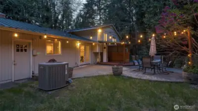This spacious and charming backyard is surrounded by beautiful greenery.