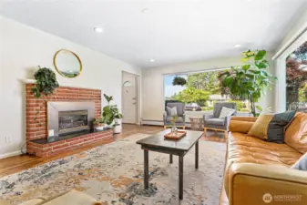 Living room boasts large windows, hardwood and gas fireplace.
