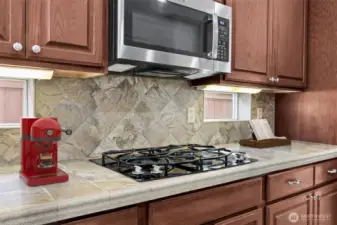 Kitchen tile tops and back splash with gas cook top and built in microwave
