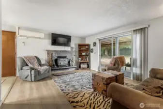 Living room with natural wood burning fireplace insert, this will warm the entire house. Mini split also shown in the picture.