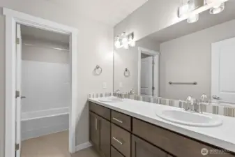 Shared full bathroom upstairs with dual sinks.