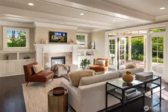 Inviting great room with gas fireplace, custom built-ins, and French doors leading to the outdoor patio.