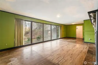 Spacious living room with floor to ceiling windows that overlook the pond and you can see the mountains