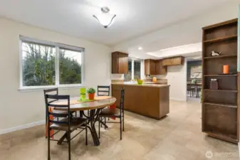 Looking back at the kitchen eating space that enjoys light and privacy provided by the large back yard and greenbelt.