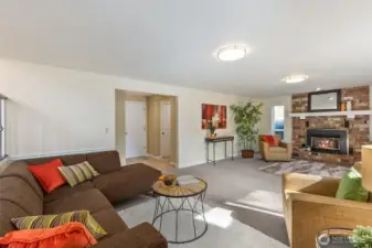 A second view of the family room shows the welcoming brick hearth, gas fireplace, and side-