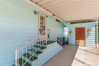 Back entrance with a storage shed and covered parking