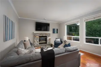 The family room on the opposite side of the kitchen with a gas fireplace that warms the area.