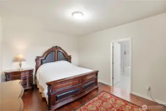 Rich engineered hardwood floors in the primary bedroom.