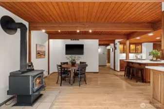 The consistent hardwood flooring seamlessly connects the culinary workspace to this inviting eating nook, centered by the timber hearth.