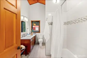 Luxury is consistent throughout. The shared bathroom features the same rich wood accents and quality craftsmanship found in the home's primary spaces.