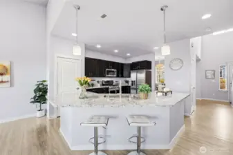 This kitchen is a great command center. The large island - ideal for gatherings, the kitchen is spacious and friendly. SS appliances, and gas cooking and baking in the double-oven cooking center. A large pantry sits conveniently to the side.