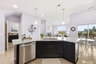 Where things get done. So much space to maneuver comfortably with helping hands at get togethers. Connected spaces make great conversations. Laundry is seen through the hallway on the left side of photo.