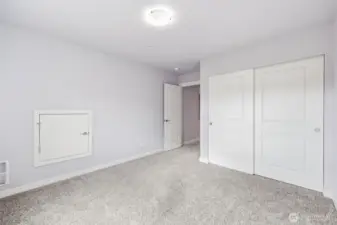 The south bedroom with views of the greenbelt, skies, and south flank of the Olympic Mountain Range including Mt. Ellinor. The wall door provides attic and furnace access with decking and lighting.