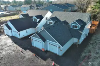 Driveways are in process, flooring has been delivered (pending install). Second duplex (left) not yet listed.