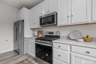 White luxe cabinetry, Stainless steel appliances and a gas top range!