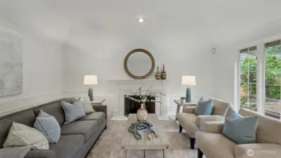 The formal living features an elegant painted mantle, wood burning masonry fireplace and coffered ceiling.