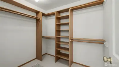 Primary suite walk-in closet with shelving offers abundant storage.