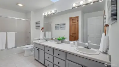 Upstairs hall bathroom with dual vanities and skylight.