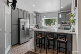1,236 sq foot upper level of the ADU has a full kitchen, pantry and breakfast bar seating area. Vaulted ceiling adds a sense of spaciousness. Living room adjoins the kitchen.