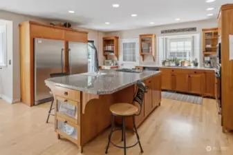 Center of the 3 BR home is the expansive kitchen anchored with Frigidaire Professional series refrigerator and freezer. The center island has a Jenn-Air range and prep sink and is open to the family room. Maple hardwood floors add warmth to the area.