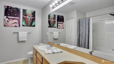 Full guest bath provides ample counter space, shower/tub combo & storage closet.