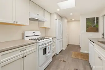 Remodeled kitchen with a gas range, laminate floors, new soft close and slide out cabinets and skylight.